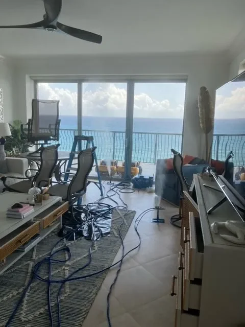 Waterfront condo living room with treatment hoses laid across the floor