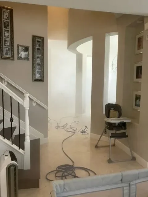 Entryway and staircase with a treatment hose running through the house