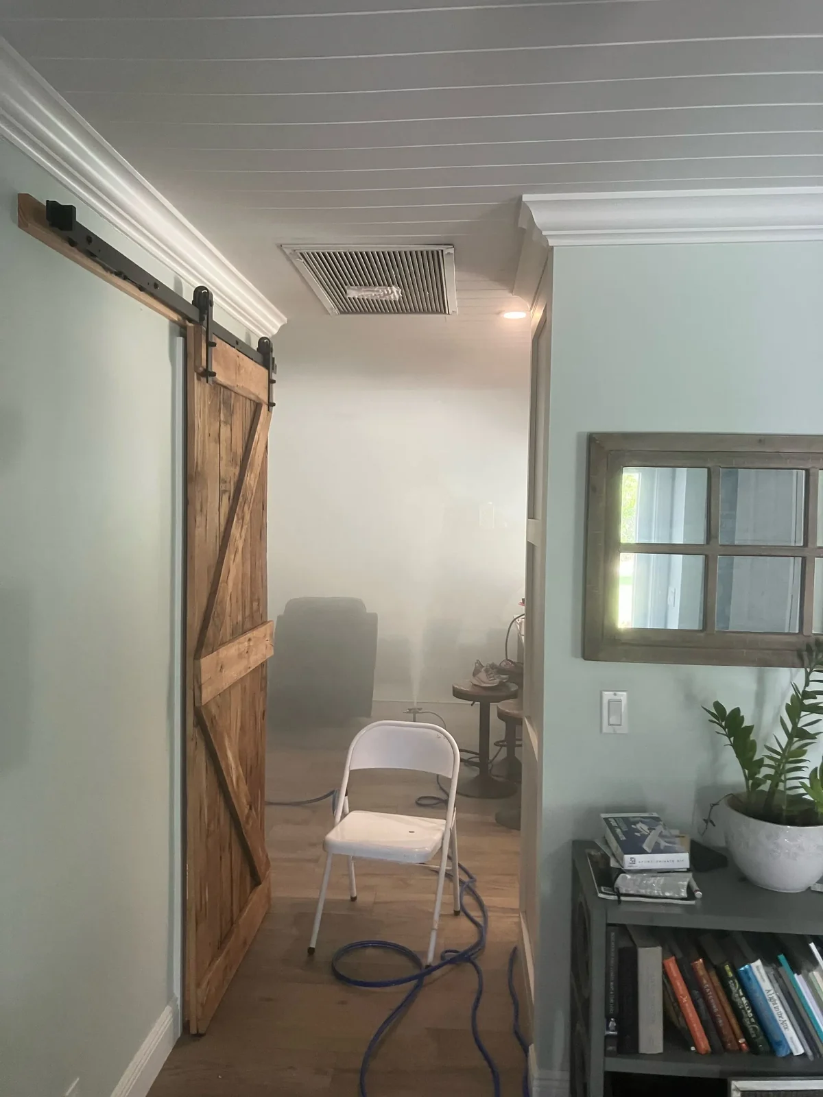 Living room with a barn door during a whole-home vapor treatment