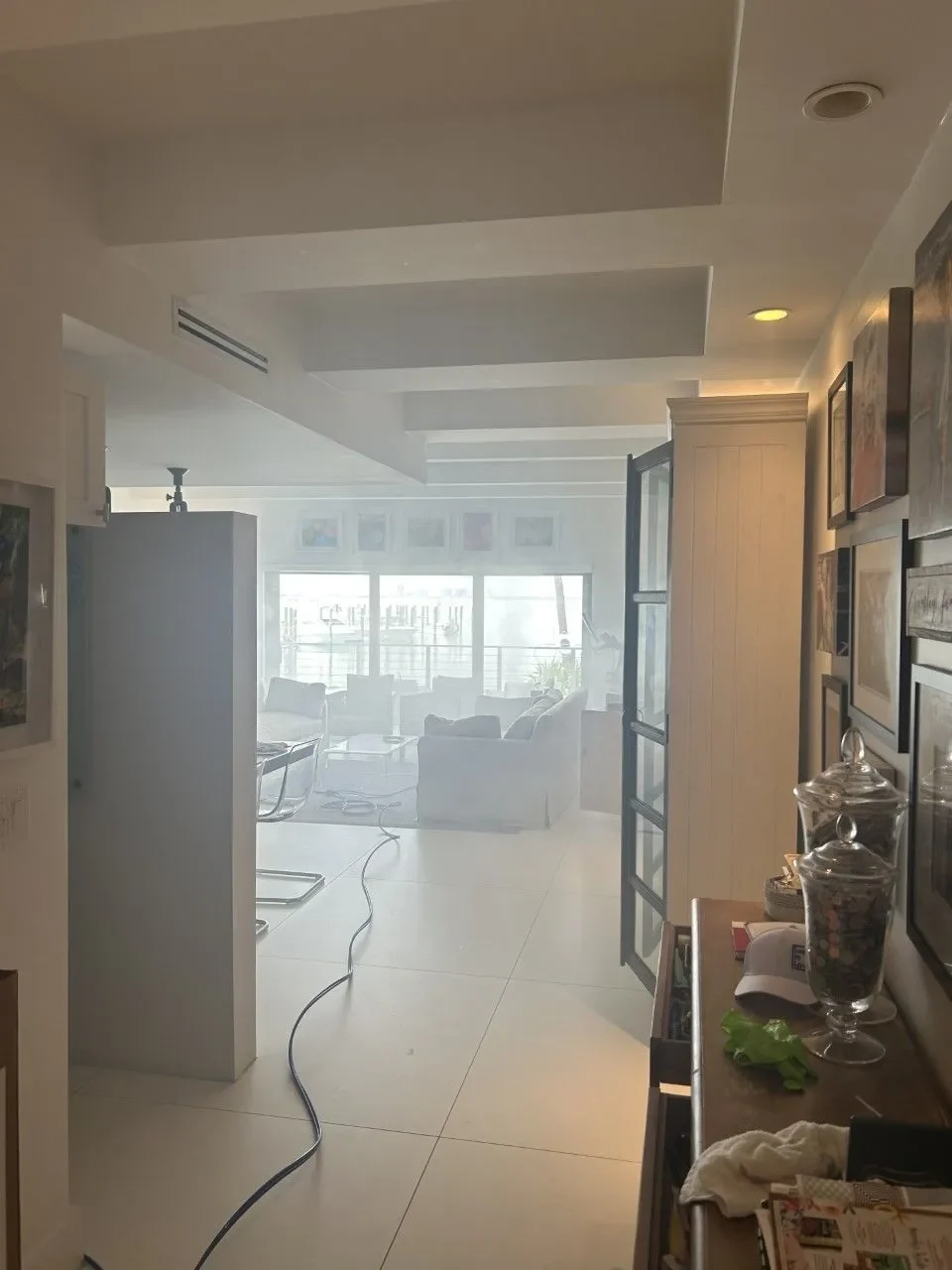 Living area with treatment vapor and a hose running across the floor